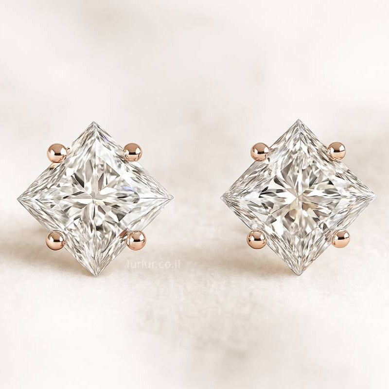 Pair of diamond stud earrings on a light background