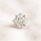 Square-cut diamond earring on a light pink background