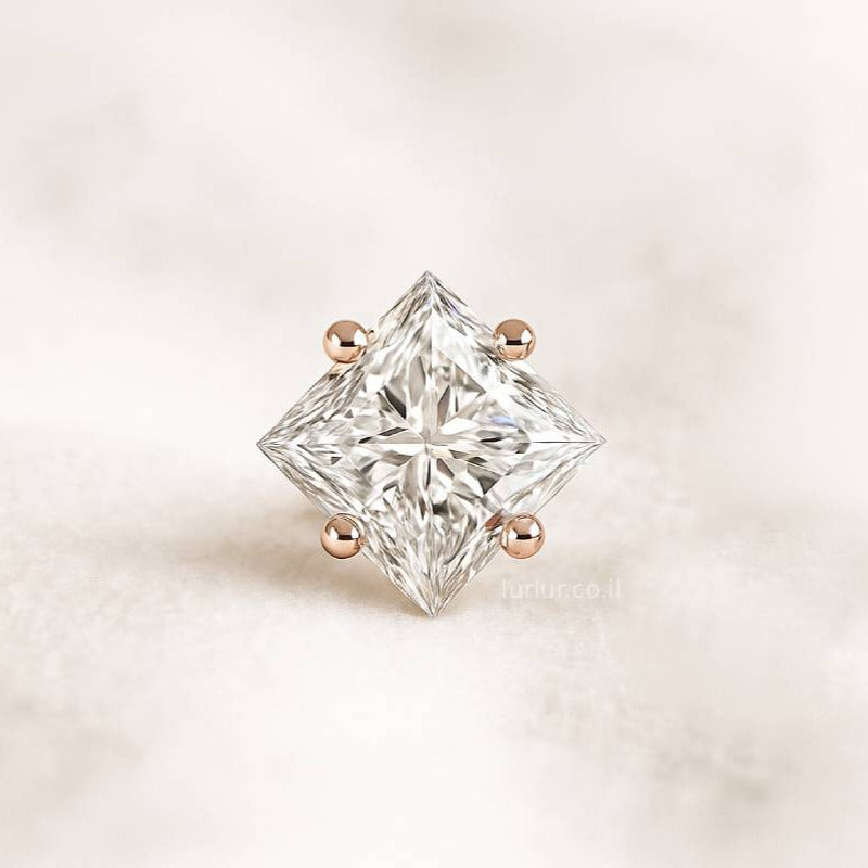 Square-cut diamond earring on a light pink background