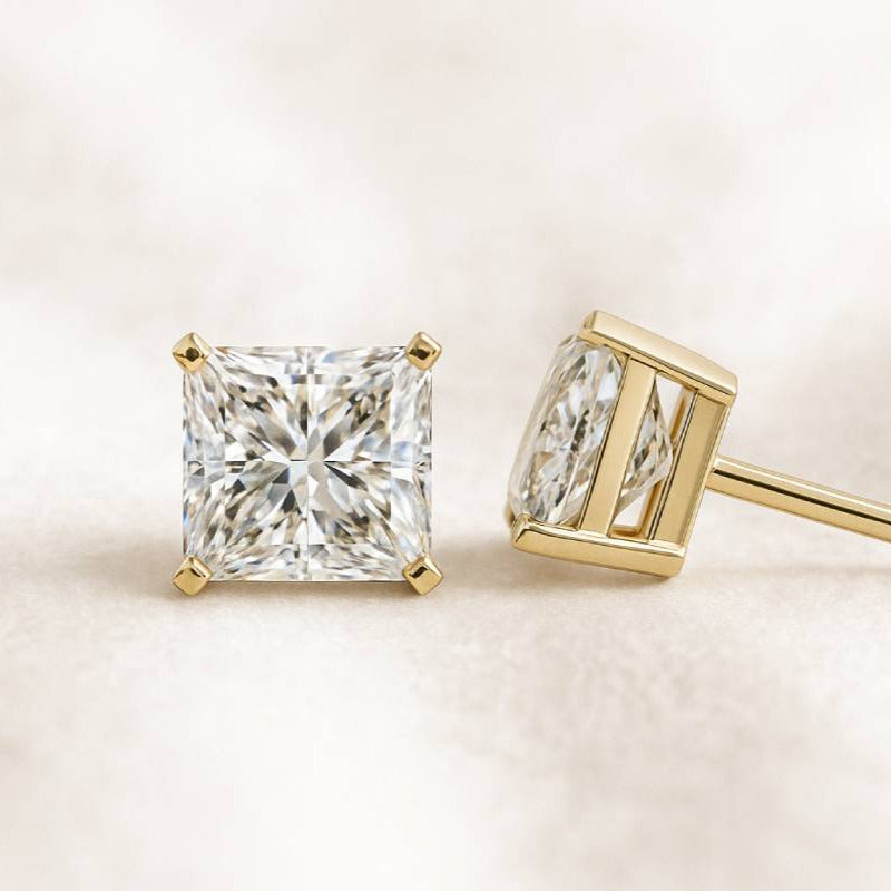 Gold diamond stud earrings on a light background