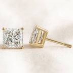 Gold diamond stud earrings on a light background