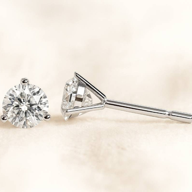 Diamond stud earrings on a light beige background