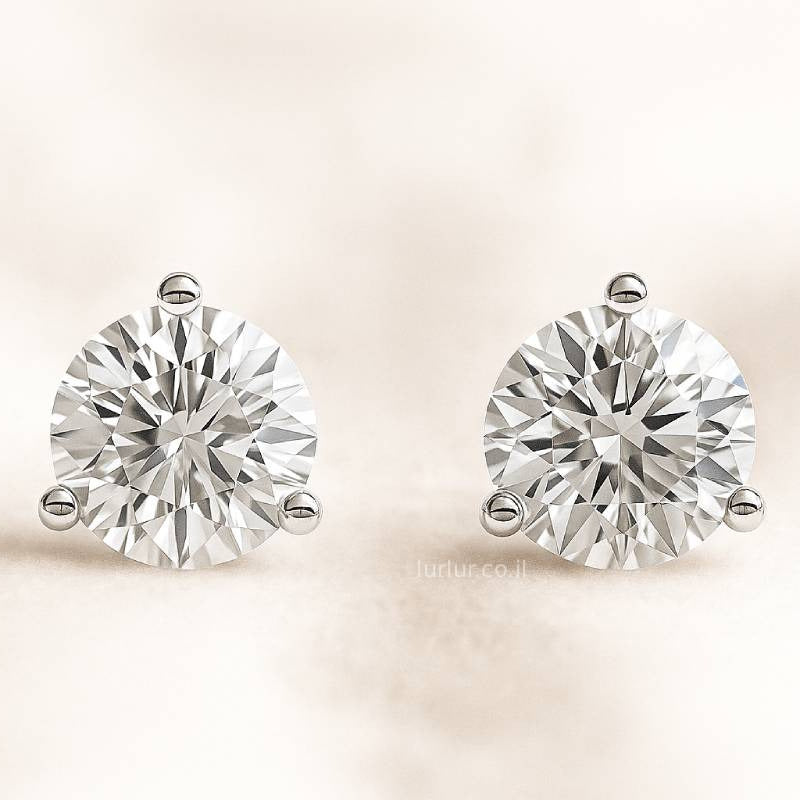 Pair of diamond stud earrings on a light beige background