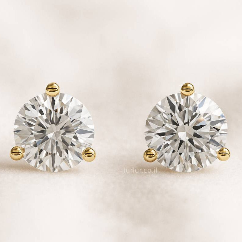 Pair of diamond stud earrings on a light beige background