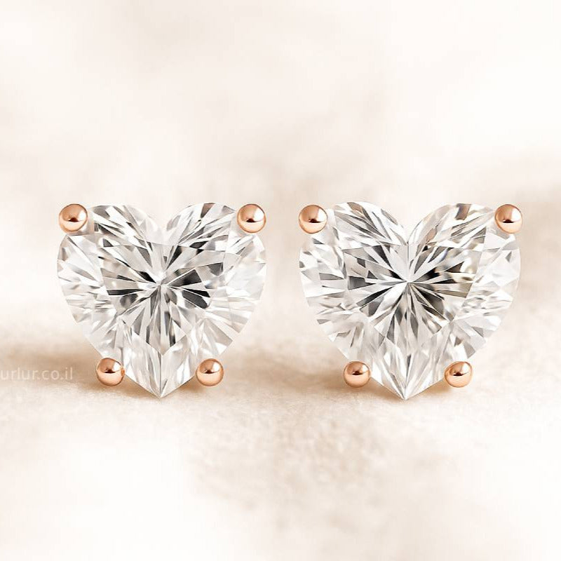 Heart-shaped diamond earrings on a beige background