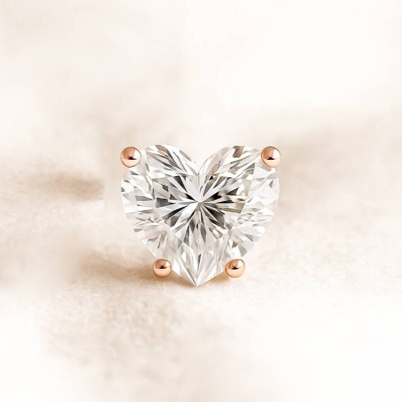 Heart-shaped diamond earring on a soft beige background