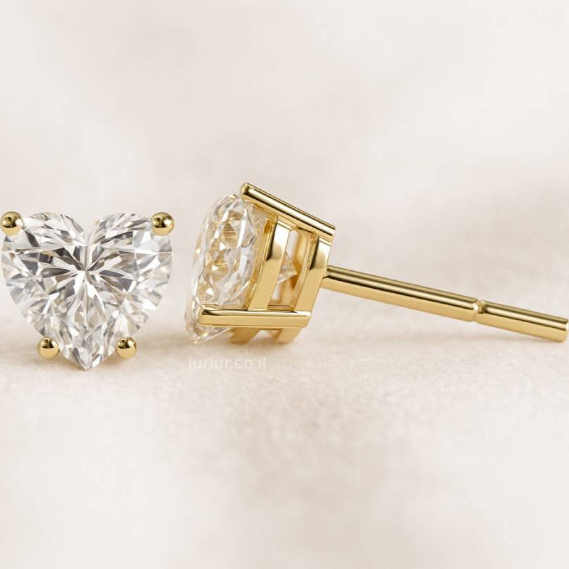 Gold diamond earrings on a light beige background