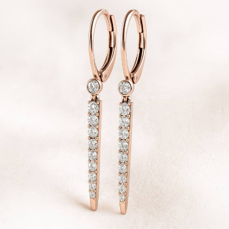 Rose gold earrings with clear gemstones on a light pink background