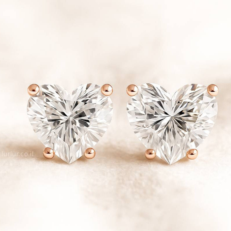 Heart-shaped diamond earrings on a beige background