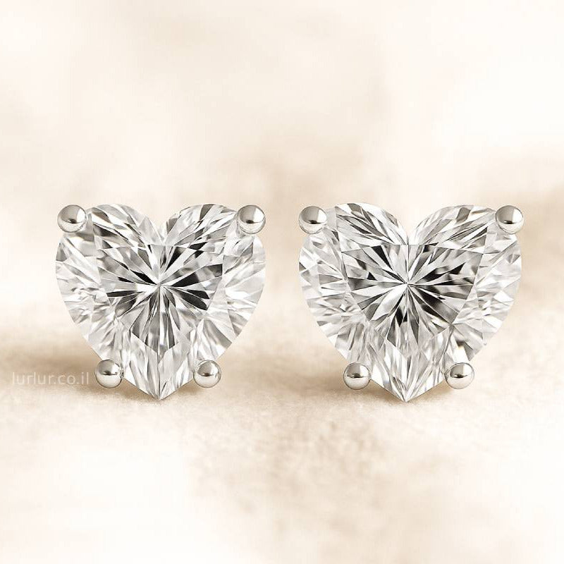 Heart-shaped diamond earrings on a beige background