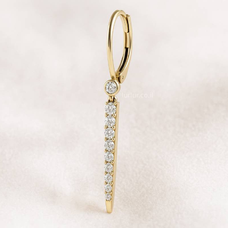 Gold earring with diamonds on a light pink background