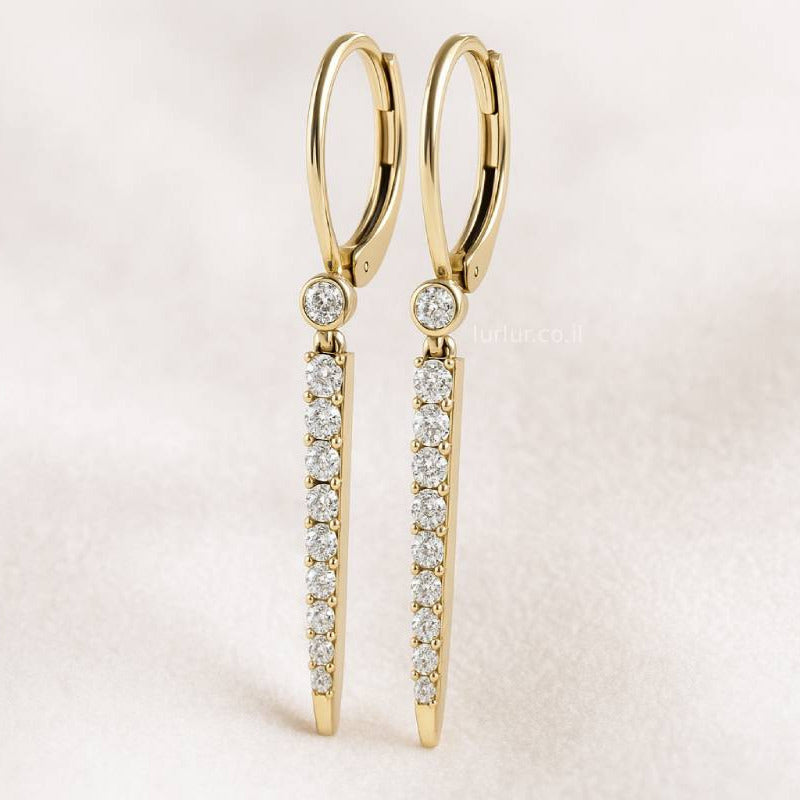 Gold earrings with diamond accents on a light pink background