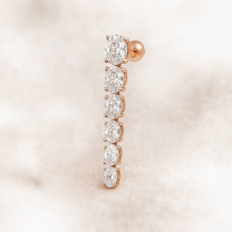 Rose gold earring with clear gemstones on a soft pink background