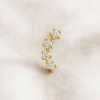 Gold and diamond earring on a light beige background