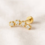 Gold earring with diamonds on a light beige background