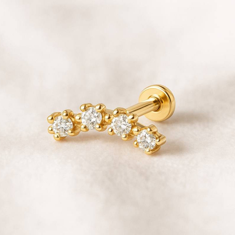 Gold earring with diamonds on a light beige background