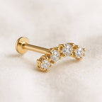 Gold earrings with embedded diamonds on a beige background