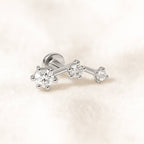  earring with three diamonds on a light pink background