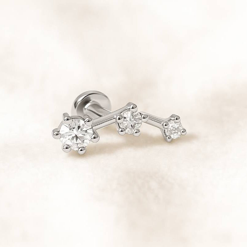  earring with three diamonds on a light pink background