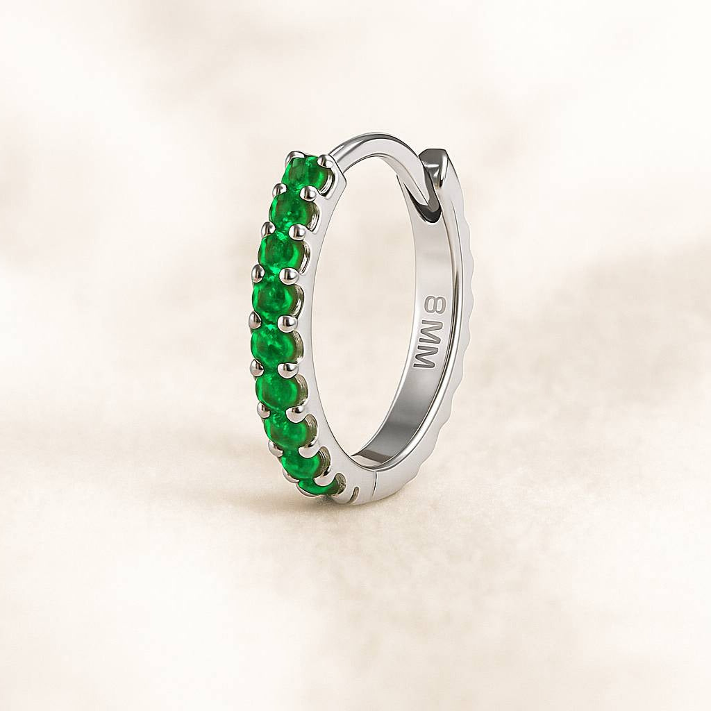  earring with green gemstones on a beige background