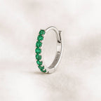 earring with green gemstones on a light background