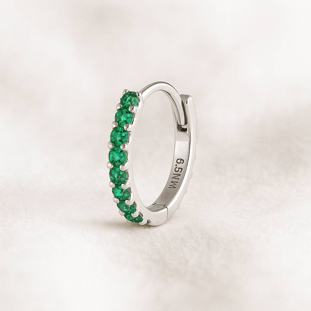 earring with green gemstones on a light background