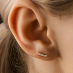 Close-up of an ear wearing a small earring with a blurred background