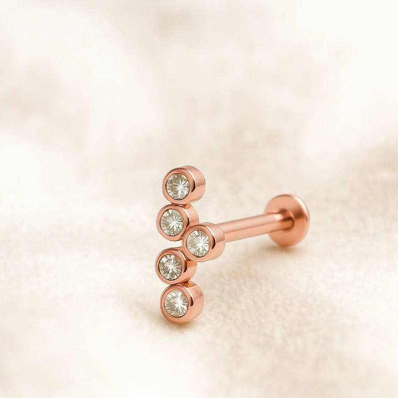 Rose gold labret with clear gemstones on a beige background