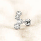 earring with three clear gemstones on a beige background