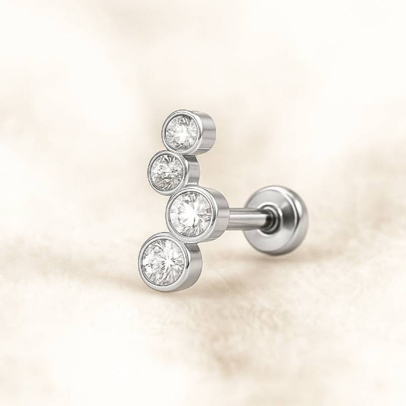 earring with three clear gemstones on a beige background