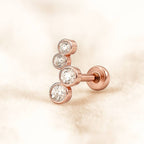 Rose gold earring with clear gemstones on a soft beige background