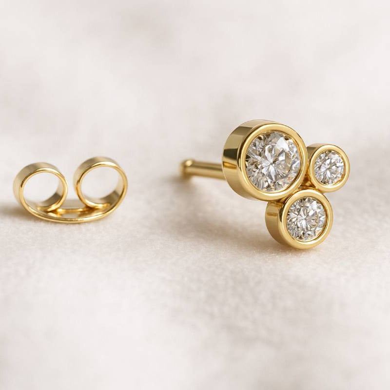 Gold earrings with gemstones on a light background