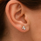 Close-up of an ear wearing 3 diamond stud earrings.