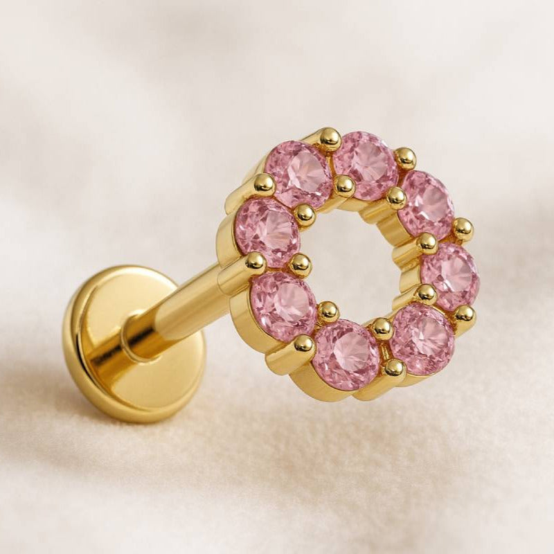 Gold and pink sapphire earring on a light background