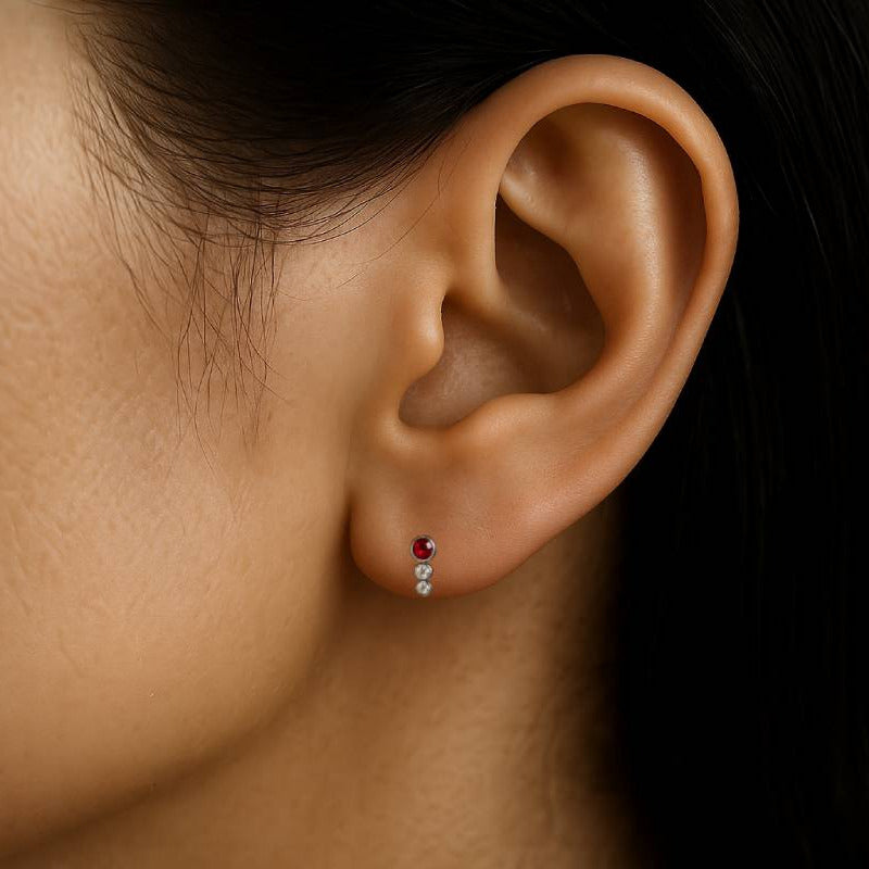 Close-up of an ear with a diamond earring on a dark background