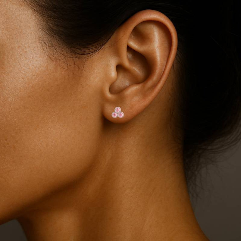 Close-up of a woman wearing a small earring with a dark background