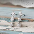 Gold and diamond earrings on a wood background