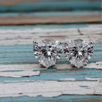 Heart-shaped diamond with gold prongs on a soft wood background