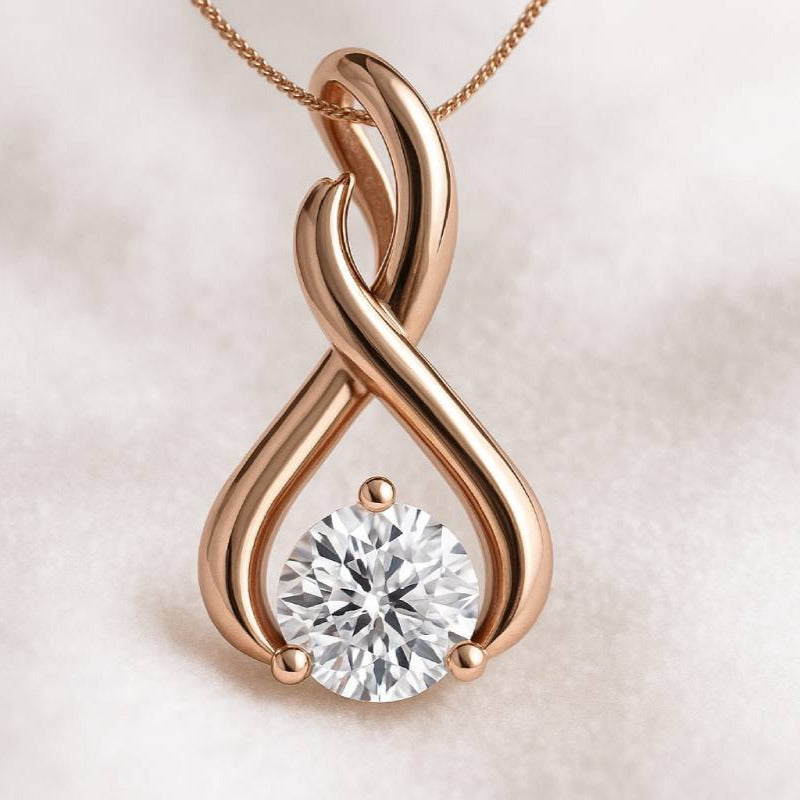 Rose gold infinity pendant with a diamond on a light beige background