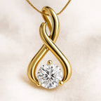 Gold infinity pendant with a diamond on a beige background