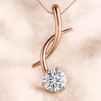 Rose gold pendant with a diamond on a soft pink background