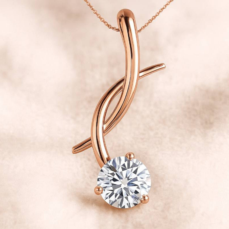 Rose gold pendant with a diamond on a soft pink background