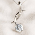 Gold pendant with a diamond on a beige background