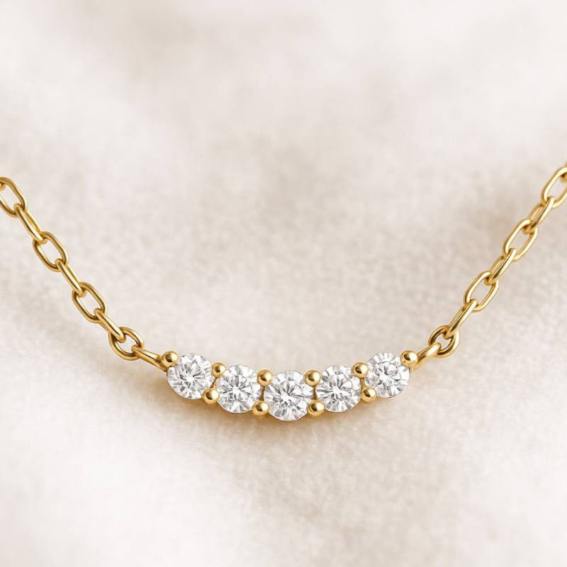 Gold necklace with diamonds on a beige background