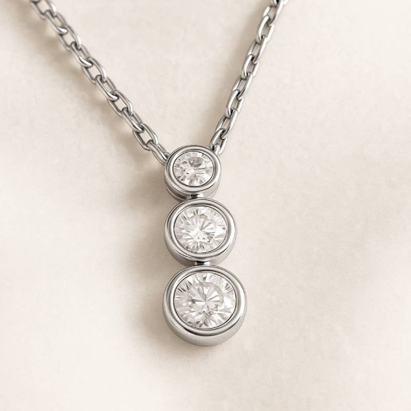 necklace with three round diamonds on a light beige background