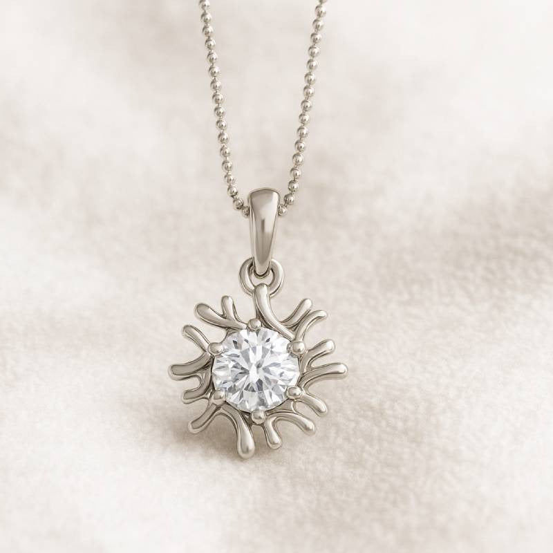 sun-shaped pendant with a clear gemstone on a beige fabric background