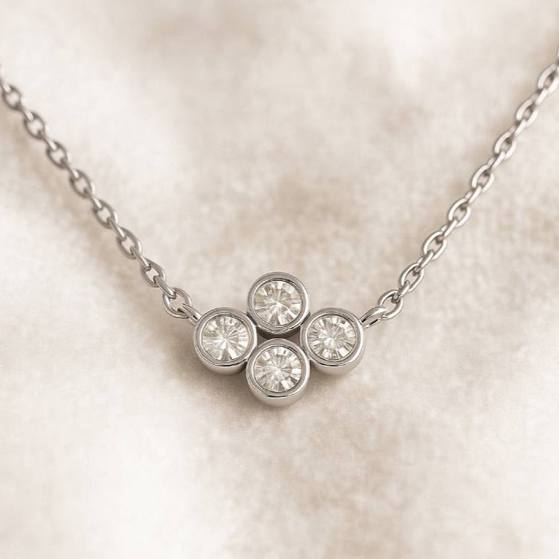  necklace with a four-stone diamond pendant on a light background