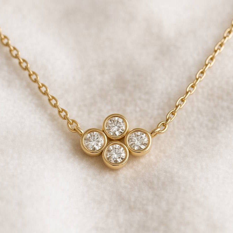 Gold necklace with a diamond pendant on a light background