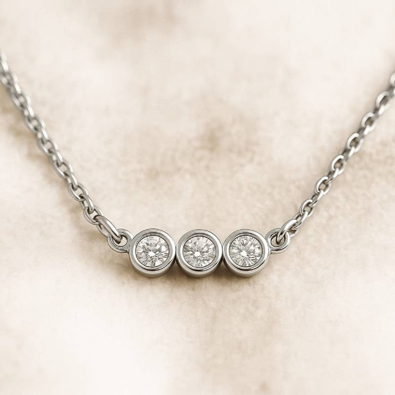  necklace with three round diamonds on a beige background