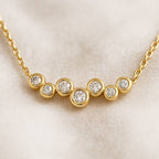 Gold necklace with small diamonds on a beige background